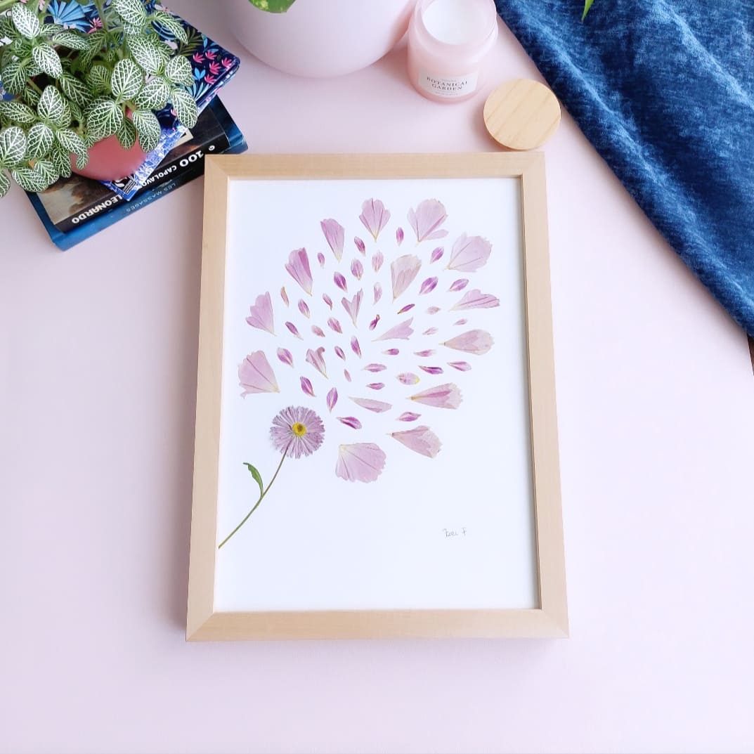 Herbier d'art Flori F. de la collection "Les Expressifs" – réalisé avec une marguerite anglaise rose à tige, des pétales de cosmos et de dahlia rose qui "s’envolent".