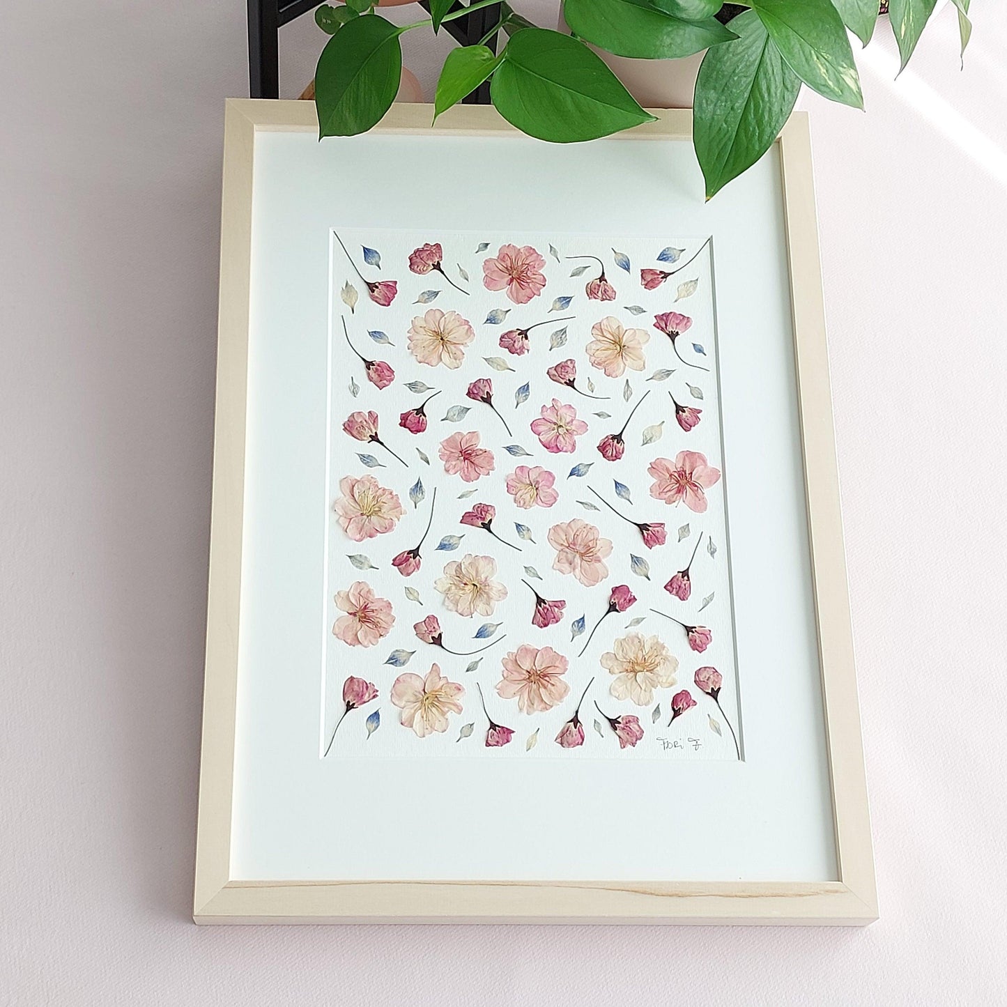 Tableau fleurs pressées et séchées réalisé à partir de fleurs de cerisier et de pétales de nigelle bleue, tous issus de sources respectueuses de l'environnement.
Cadeau parfait pour Noël, la fête des mères, Saint Valentin, anniversaire, etc.