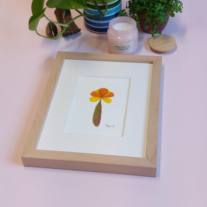 Composition florale minimaliste, réalisée avec des pétales de fleurs de cosmos jaunes et oranges que j'ai cueillis dans les champs fleuris de Luke et Angela de la ferme florale&nbsp;"Au Château Fleuri", située à Schwerdorff en Moselle, France. Ces pétales ont été sublimés par une feuille de sumac de Virginie leur servant de tige, cueillie, elle aussi, en terre mosellane.