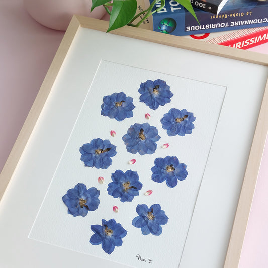 Herbier d'art encadré, réalisé à partir de fleurs de delphinium bleu et de pétales de gomphrena globosa, tous issus de sources respectueuses de l'environnement. Cadeau parfait pour la fête des mères. 